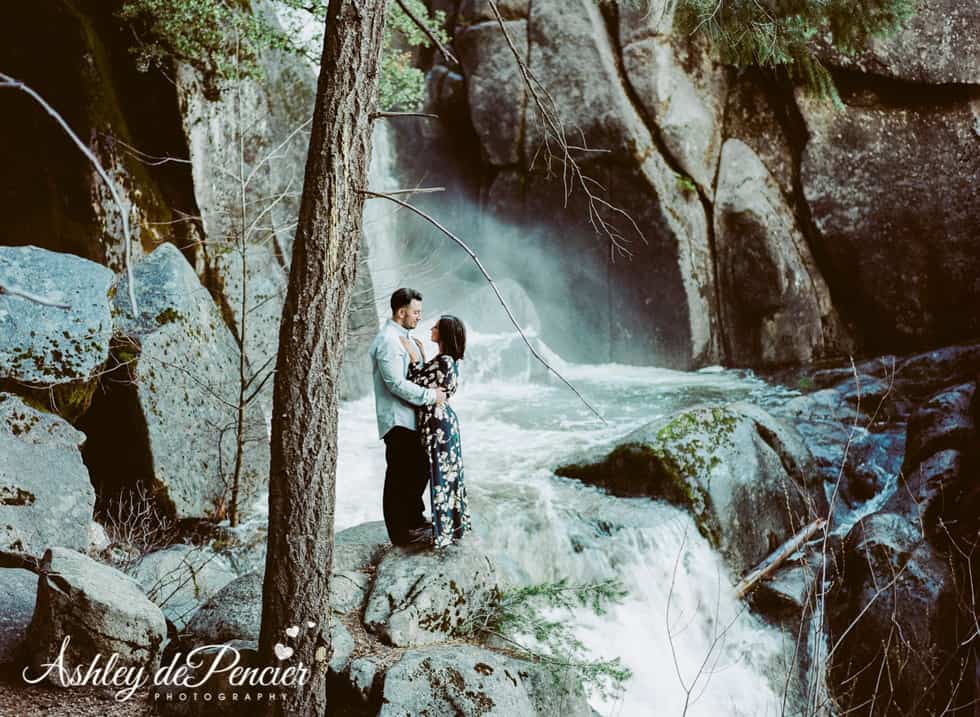 Man and woman standing by a waterfall