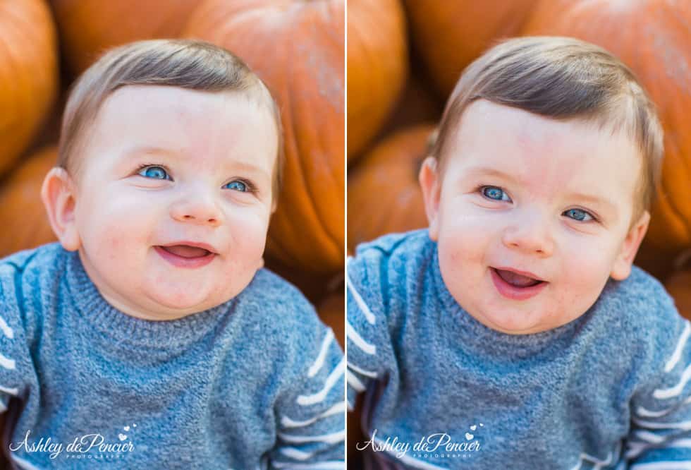 Little boy sitting next to pumpkins smiling