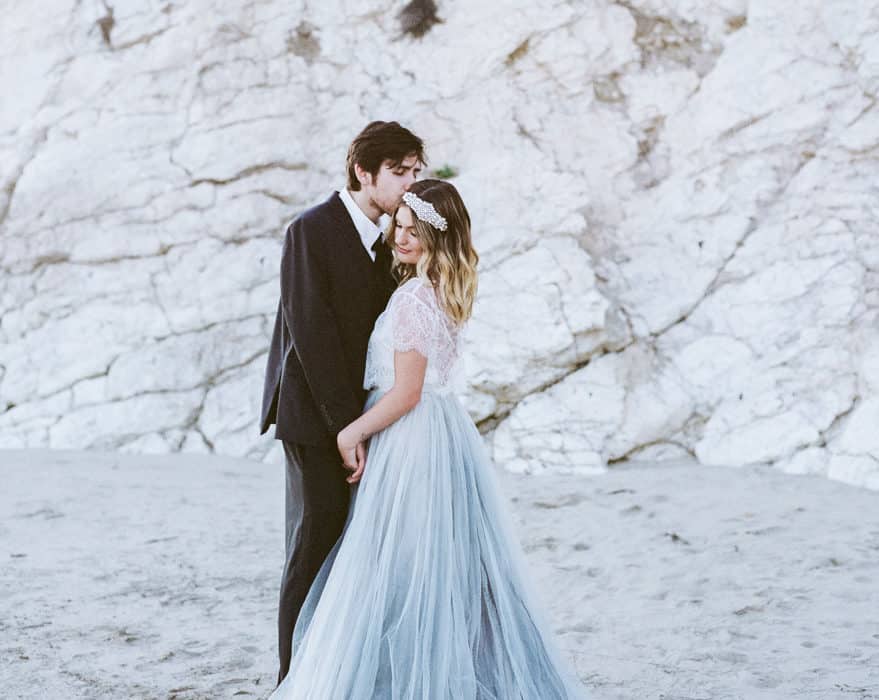 Bride and groom standing on the beach