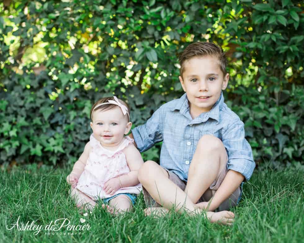 Brother and sister sitting in the grass