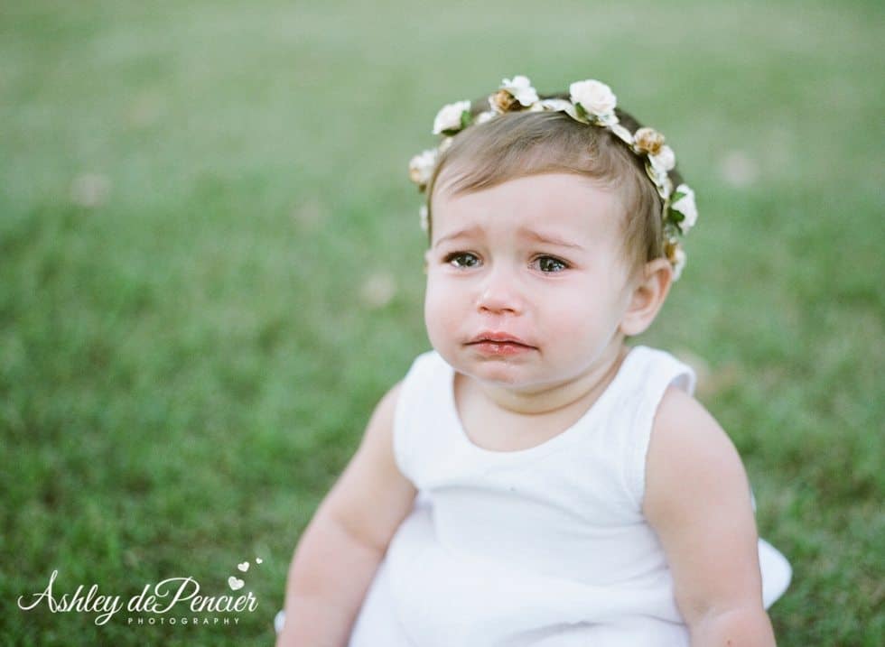 Little girl sitting outside crying