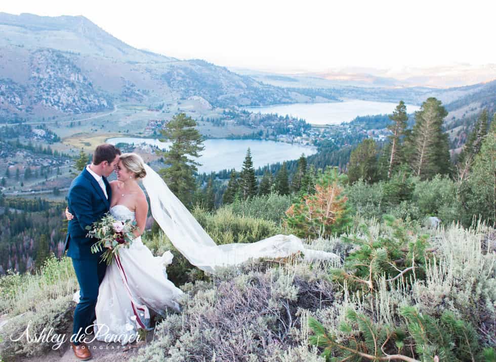 Bride and groom standing in front of June Lake